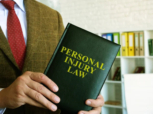 Personskadelagen. En advokat i kostym håller i en bok. — Stockfoto