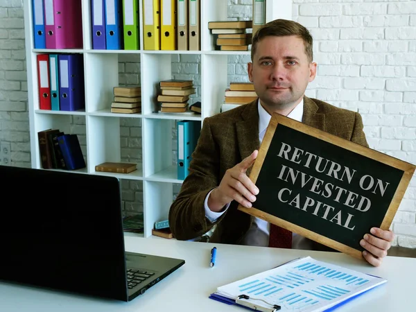 Rendement van geïnvesteerd kapitaal ROIC. De accountant heeft een teken.. — Stockfoto
