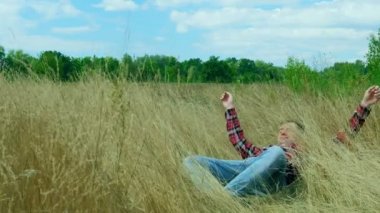Adam doğada dinleniyor. Sonbahar sarı çimlerine düşer. Doğada rahatlama.
