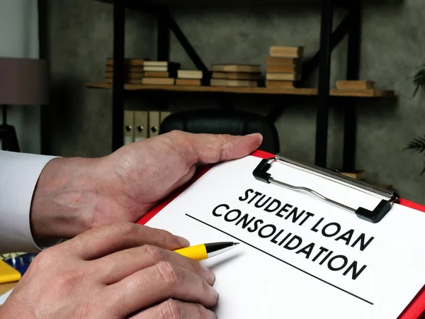 L'homme remplit le formulaire pour la consolidation du prêt étudiant. — Photo