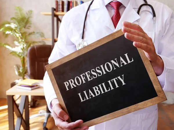 The doctor holds a sign with the Professional liability inscription. — Stock Photo, Image