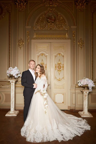 Encantadora pareja de boda en el interior en estilo barroco se abraza en el gran palacio real — Foto de Stock