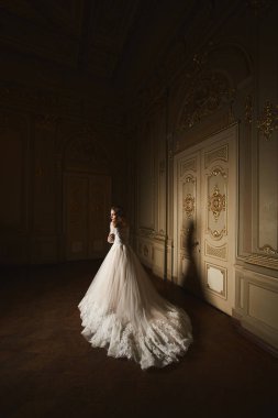 Uzun zarif beyaz elbiseli güzel kadın moda portre. Zarif saç modeli olan kız. Gelin moda model lüks iç barok tarzı