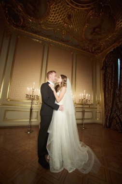 İki lüks bir iç barok tarzı içinde düğün birbirlerine sarılıyor. Beyaz elbiseli güzel model kız. Takım elbiseli adam. Güzellik gelinle damat. Kadın ve erkek portre. Dantel kadınla