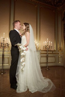 İki lüks bir iç barok tarzı içinde düğün birbirlerine sarılıyor. Beyaz elbiseli güzel model kız. Takım elbiseli adam. Güzellik gelinle damat. Kadın ve erkek portre. Dantel kadınla