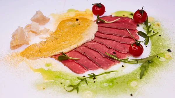 Sliced pieces of fried beef pastrami with colored sauces — Stock Photo, Image