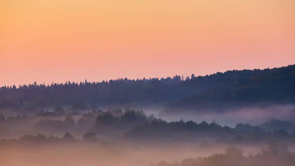 Misty morning of hilly area with ray of light. — Stock Photo, Image