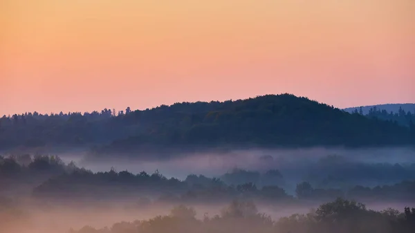 Misty morning of hilly area with ray of light. — Stock Photo, Image