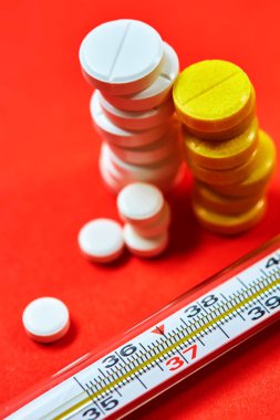 Merkür termometre ve arka plan üzerinde tıbbi ilaçlar