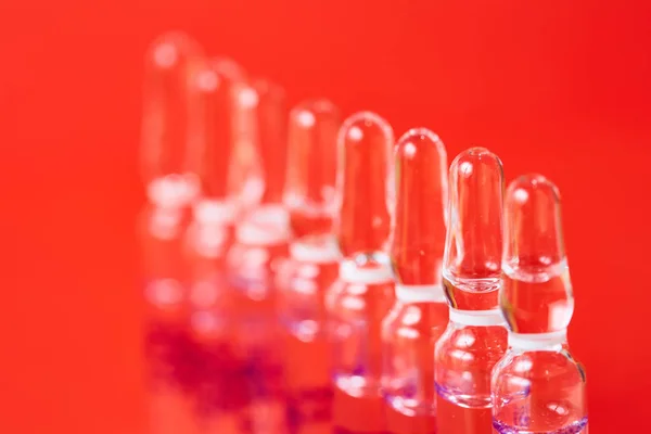 Medical ampules on a red background, selective focus. — Stock Photo, Image