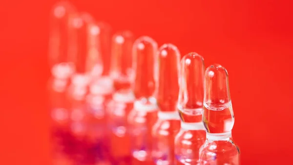 Medical ampules on a red background, selective focus. — Stock Photo, Image