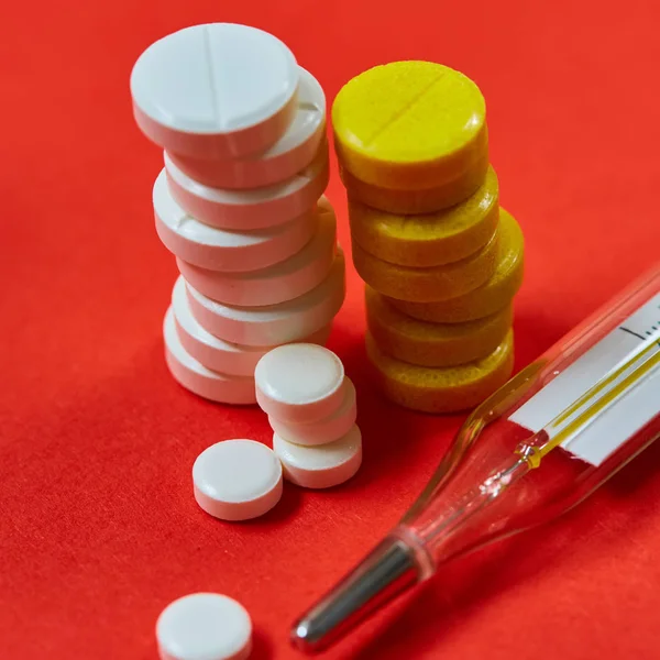 Mercury thermometer and medical pills on background — Stock Photo, Image