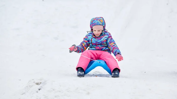 Vrolijk Meisje Rijden Een Slee Bergafwaarts Een Besneeuwde Slee Parcours — Stockfoto