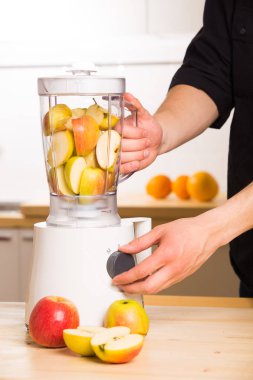 Genç adam elma smoothie blender pişirme