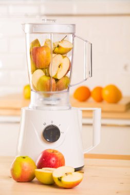 Genç adam elma smoothie blender pişirme
