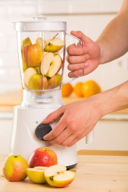 Genç adam elma smoothie blender pişirme