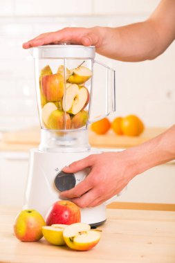 Genç adam elma smoothie blender pişirme