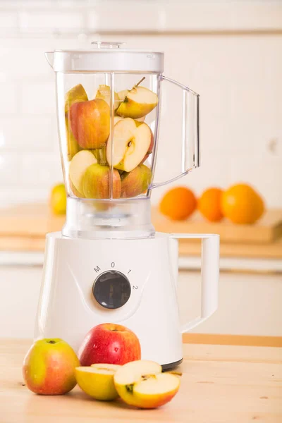 Ung man matlagning äpple smoothie i mixer — Stockfoto