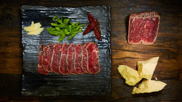 Barbecue wagyu roast beef sliced as top view on a metal tray with copy space right — Stock Photo, Image