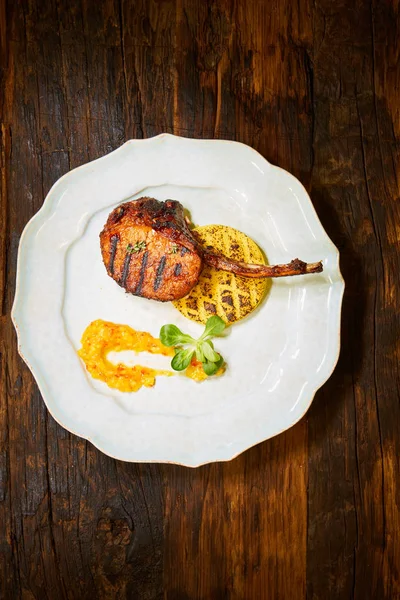 Kuzu kaburga baharat ve beyaz tabakta sos ile kavrulmuş. Sığ dof