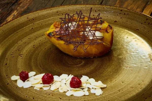 Жареный грушевый десерт, украшенный шоколадом и миндалем — стоковое фото