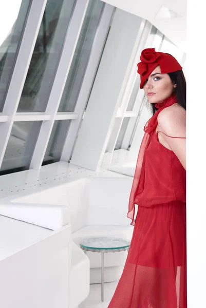 Vacker ung modern kvinna poserar i röd klänning och red hat. Vogue stil. Foto med instagram stil filter — Stockfoto