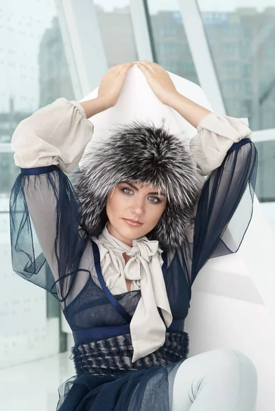Modèle de fille de mode posant en fourrure chapeau en fourrure. Belle femme en vêtements de luxe à l'intérieur blanc — Photo