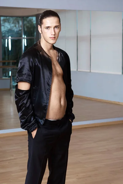 Homme dans une suite élégante posant dans une salle de fitness. Haute couture jeune homme sexy en short noir et une veste noire . — Photo