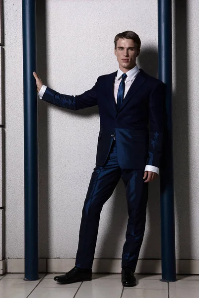 Portret van een aantrekkelijke jonge zakenman in stedelijke achtergrond blauwe pak en stropdas dragen. Op zoek naar de camera. Klassieke stijl. — Stockfoto