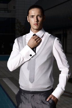 Takım elbise ve kravat giyen kentsel arka planda çekici bir genç işadamı portresi. Kameraya bakıyor. Klasik stili.