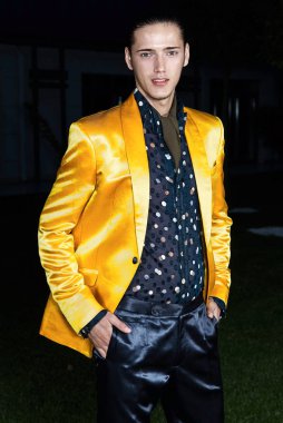 Sarı Ceket daimi yeşil çimenlerin üzerinde çekici şık adam. Kameraya bakıyor. Klasik tarzı. Stüdyo vurdu