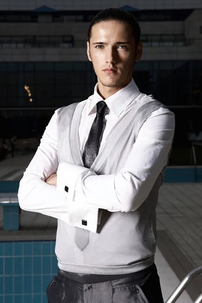 Portrait of an attractive young businessman in urban background wearing suit and necktie. Looking to the camera. Classic style. — Stock Photo, Image