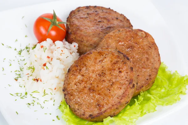 Three fried breaded cutlet with lettuce, tomatoes and rice on white background — Stock Photo, Image