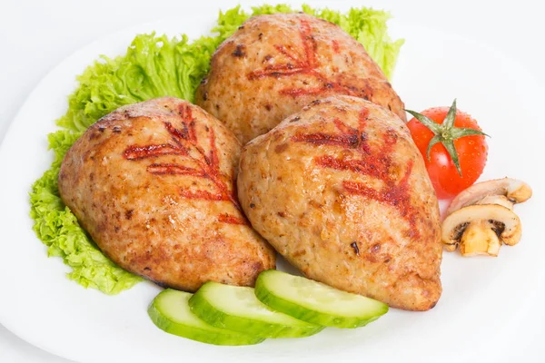 Three fried breaded cutlet with lettuce, tomatoes, cucumbers and mushrooms on white background — Stock Photo, Image