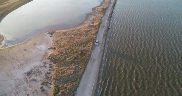 4 k luchtfoto drone weergave van Azov liman kustlijn. Offroad auto rijden aan de kust van de zee van Azov bij zonsondergang — Stockvideo