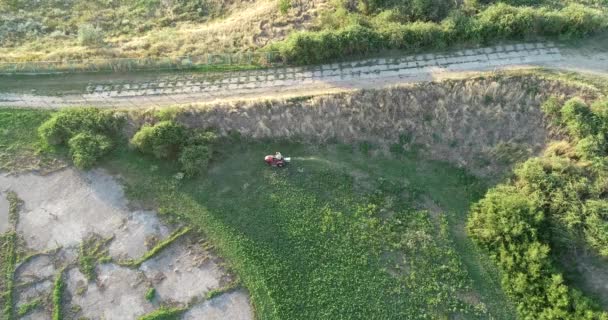 Uma vista aérea de um homem cortando seu gramado com um cortador de grama . — Vídeo de Stock