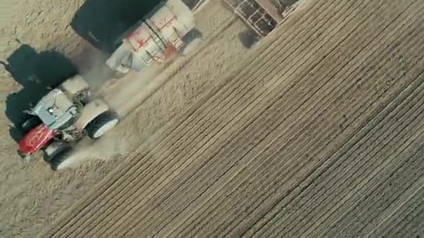 Aerial: Lonely tractor plow the wheat field — Stock Video