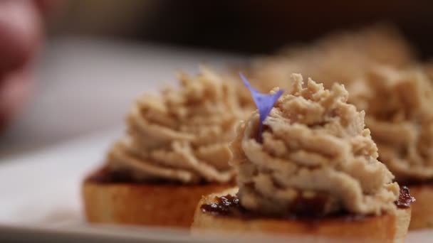 Chef-kok garnishes pate met eetbare paarse bloemblaadjes — Stockvideo