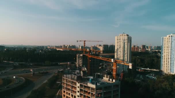 Строительный кран и здание на фоне голубого неба — стоковое видео