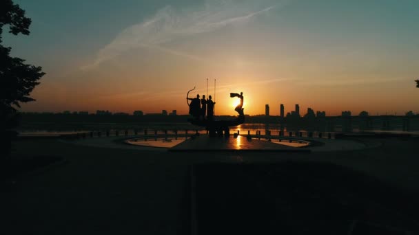 Monument voor de oprichters van Kiev bij zonsopgang, mooie stadsgezicht in de brandende zon. Standbeeld van Kyi, Shchek, Horyv en Lybid over de Paton-brug. Hoofdstad van Oekraïne — Stockvideo