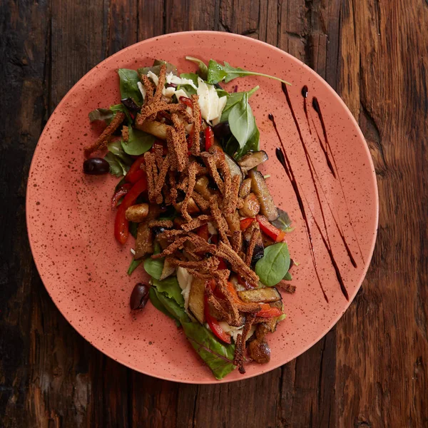 Aubergine cuite à la salade avec oignons verts, croûtons et tomates sur fond de bois . — Photo