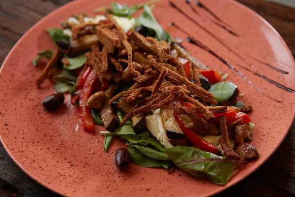 Ensalada de berenjena al horno con cebolla verde, croutons y tomates sobre fondo de madera . — Foto de Stock