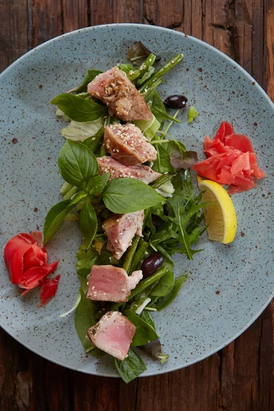 Mooie eten: biefstuk tonijn in sesam, limoen en verse salade close-up op een plaat op tafel. — Stockfoto