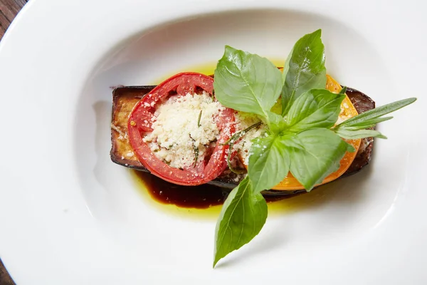 Berinjela assada com queijo parmesão, tomate e manjericão . — Fotografia de Stock