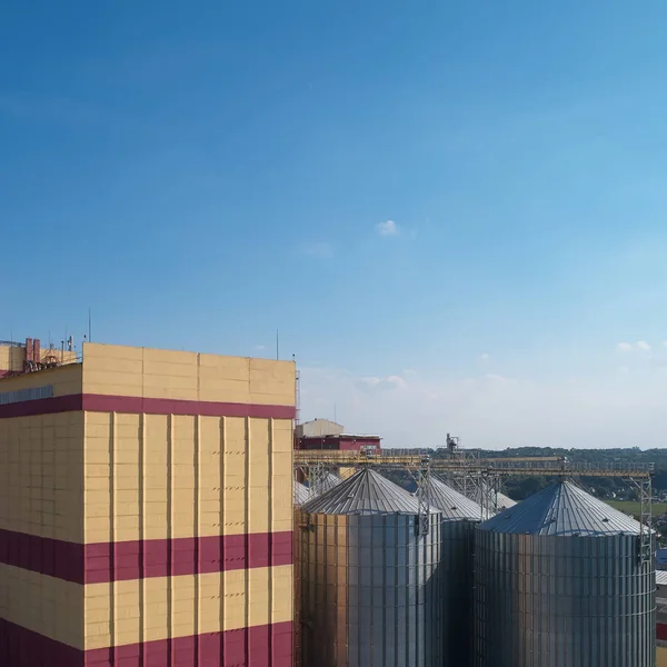 Agricultural Silo. Storage and drying of grains, wheat, corn, soy, against the blue sky with clouds. — Stock Photo, Image