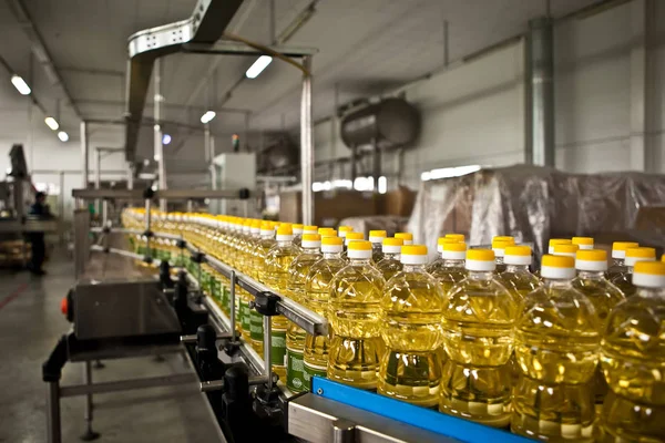 Aceite de girasol en la botella en movimiento en la línea de producción. Dof poco profundo . — Foto de Stock