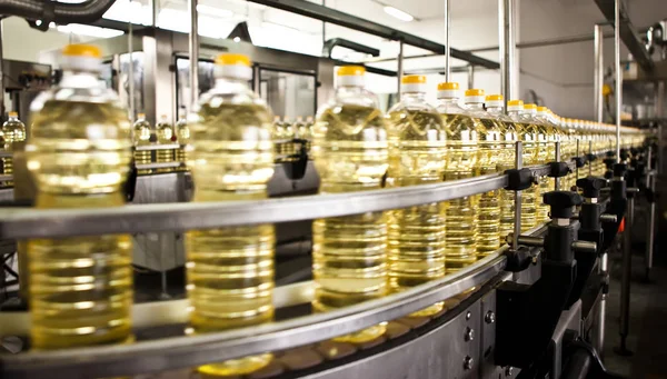 Aceite de girasol en la botella en movimiento en la línea de producción. Dof poco profundo . —  Fotos de Stock