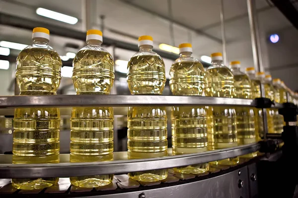Sonnenblumenöl in der Flasche in Bewegung auf dem Produktionsband. flacher dof. — Stockfoto