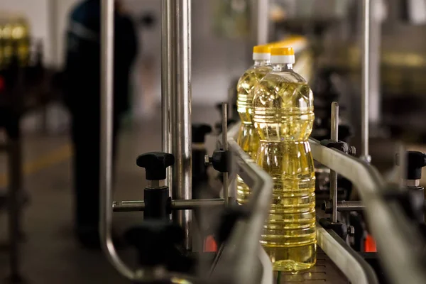 Huile de tournesol dans la bouteille se déplaçant sur la chaîne de production. Dof peu profond . — Photo