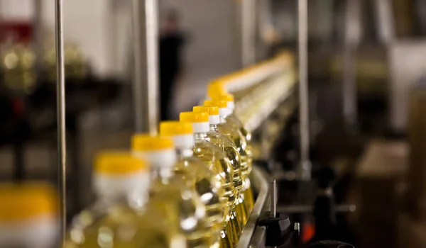 Sunflower oil in the bottle moving on production line. Shallow dof. — Stock Photo, Image